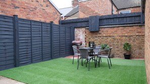 Enjoy al fresco dining in an outdoor space with a lawn, dining area, and barbecue grill.