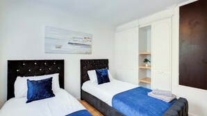 Un dormitorio con dos camas, un espejo grande y un cuadro en la pared.