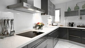 A modern kitchen with a central island, stainless steel appliances, and black cabinets. - My Rental Homes - Villa Floresta private pool and large garden (Sant Antoni De Portmany)