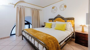 A bedroom with a bed, curtains, a nightstand, a lamp, and wall decor. - Amedei Apartment: 2 suites {10 m from Ponte Vecchio} (Firenze)
