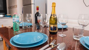 A kitchen counter with blue plates, wine glasses, a bottle of champagne, and a bottle of water. - Amedei Apartment: 2 suites {10 m from Ponte Vecchio} (Firenze)
