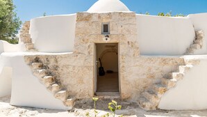 Ein traditionelles Steinhaus mit einer weißen Kuppel und einem Eingang.