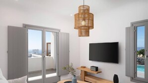 Un salon moderne avec une grande télévision, une table basse en bois et un luminaire suspendu en osier.