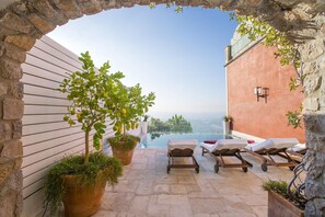 A rooftop terrace with a clear view of the sea, stone walls, and lounge chairs. - Villa Chiara with swimming pool - My Rental Homes (Praiano)