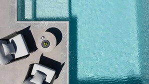 An aerial view of a pool area with two lounge chairs and a round table. - Villa Estia with heated pool - My Rental Homes (Kappariés)