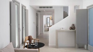 A modern interior with a dining area, a staircase, and a view of the outdoors. - Villa Estia with heated pool - My Rental Homes (Kappariés)