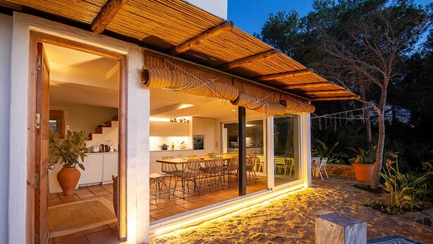 Una casa moderna con una cocina espaciosa, zona de comedor y un patio con piso de piedra.
