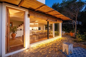 Una casa moderna con una cocina espaciosa, zona de comedor y un patio con piso de piedra.