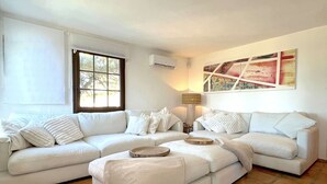 Una sala de estar con un sofá blanco, una mesa de centro y una lámpara de pie.