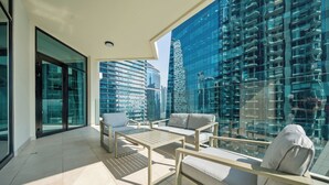 A modern balcony with a glass railing, offering a view of surrounding high-rise buildings. - Stylish 2BR Fully Furnished Unit at Business Bay (Dubai)