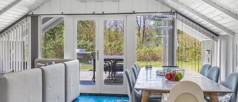 Une terrasse couverte avec une table à manger, des chaises et un canapé.