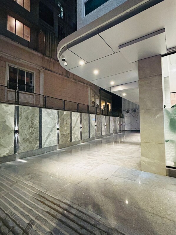 A spacious indoor corridor with a marble floor, a curved ceiling, and a glass wall on one side. - Hotel Flexi Residency Mumbai (Mumbai)