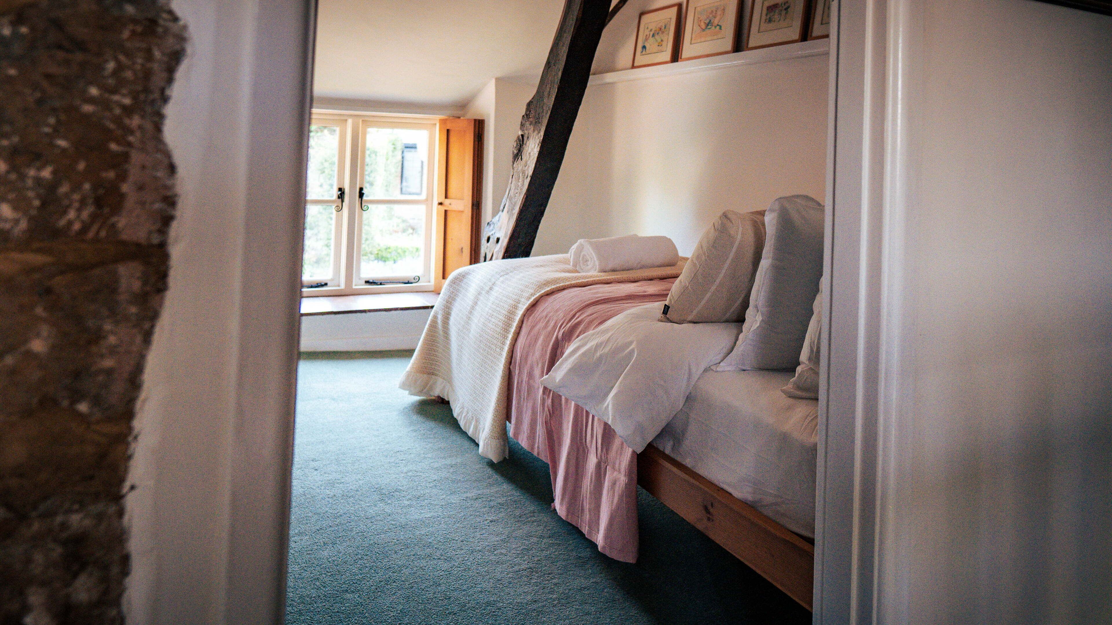 Une chambre à coucher avec un lit, une fenêtre et un escalier.
