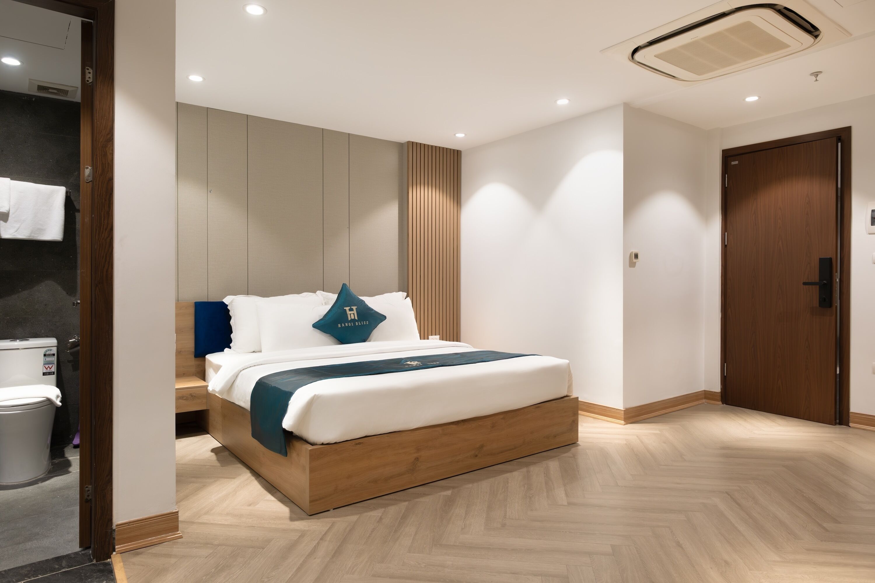 A modern bedroom with a wooden bed frame, a bedside table, and a built-in wardrobe.
