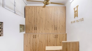 Een kamer met houten kasten, een plafondventilator en een bord aan de muur met de tekst 'HANOI BLISS'.