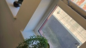 A room with a large window, a potted plant, and a framed picture on the wall. - Luxury Stylish Charming City Apartment With Private Entrance in Wolverhampton (Wolverhampton)
