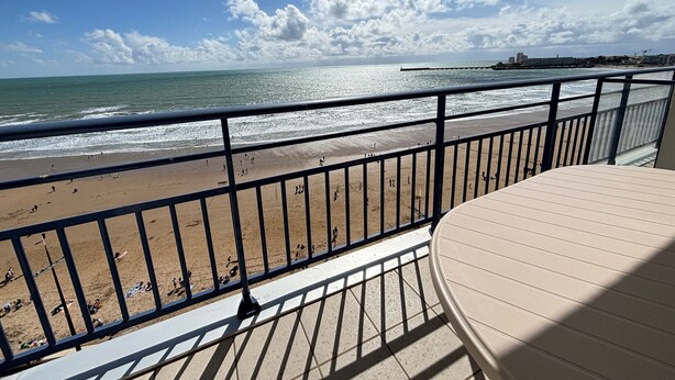 Un balcón con vista a la playa y al océano.