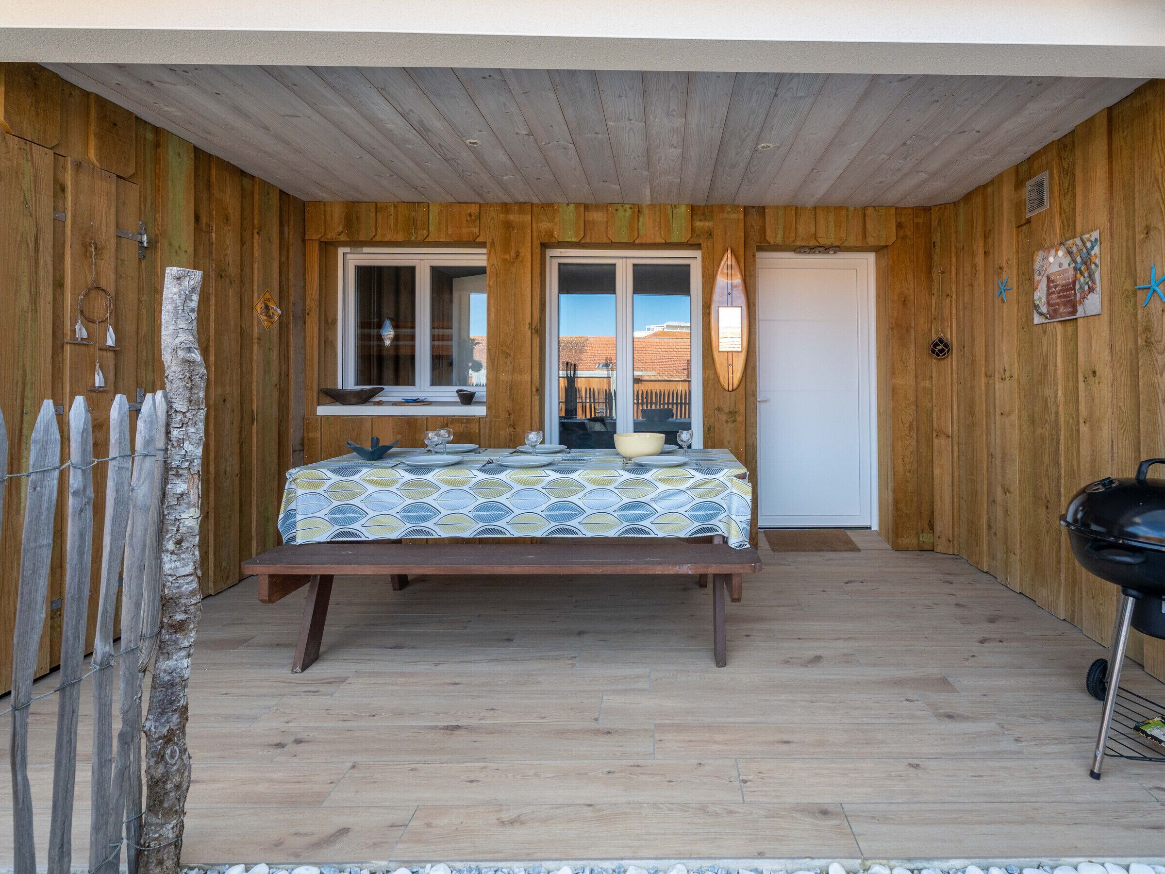 Une cabane en bois avec un lit, une table à manger et un barbecue.