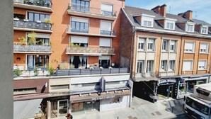 A multi-story building with balconies, a ground-floor shop, and a visible entrance. - Zen Duplex in Valenciennes city center (Valenciennes)