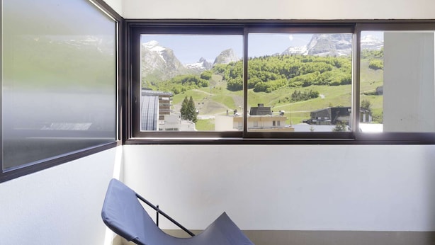 Une pièce dotée d’une grande fenêtre donnant sur un paysage montagneux.