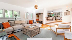 Un salon moderne comprenant un canapé, une table basse et un coin repas avec une chaise et une table.