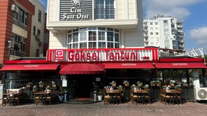 A building with a sign for 'Goksel Tantuni' and 'Cim Suite Oel'. - Cim Pansiyon (Antalya)