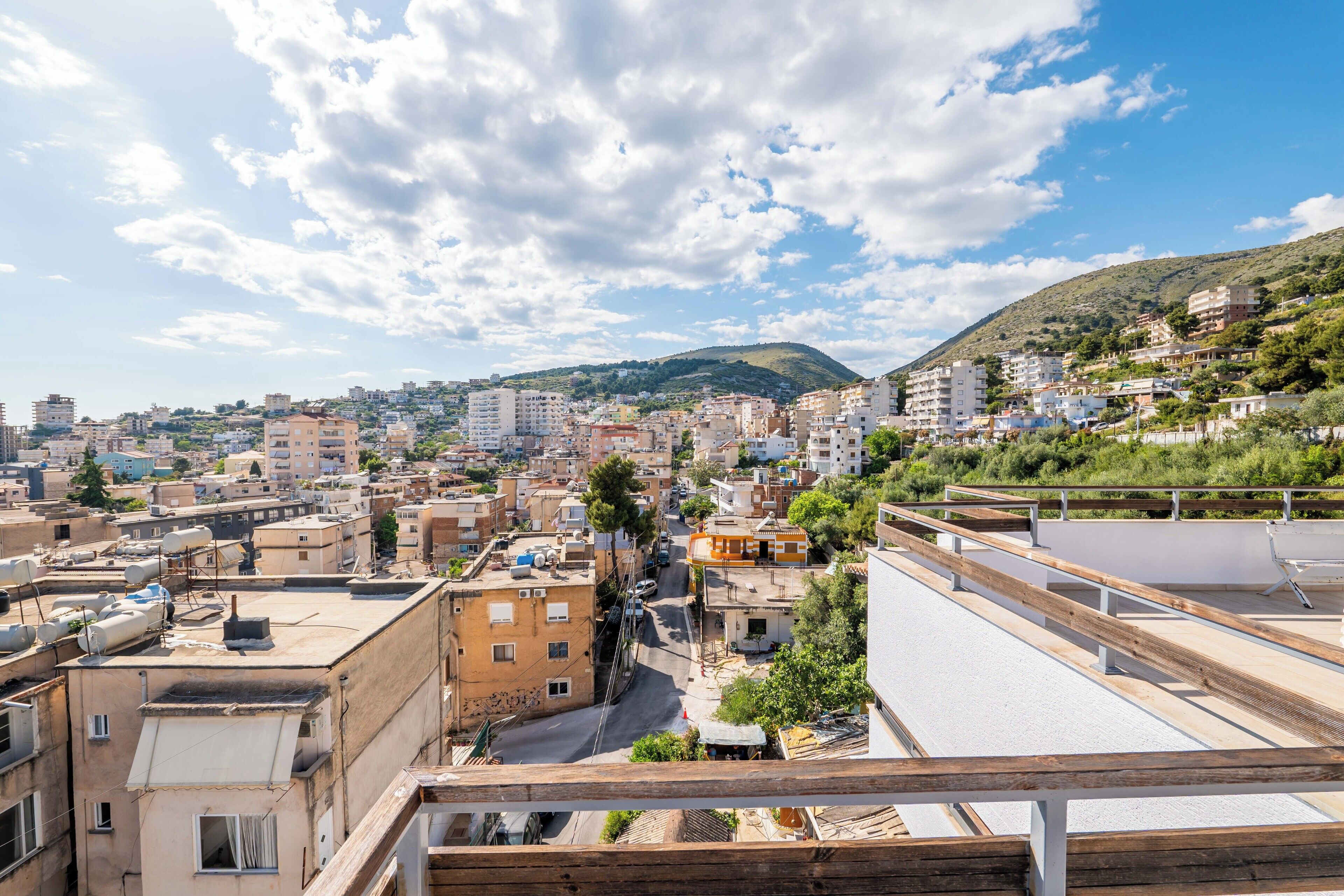 Un paisaje urbano con edificios, una carretera y una colina al fondo.