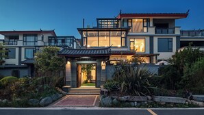 Ein modernes Haus mit traditionellem Dach, großen Fenstern und einem gepflegten Garten.