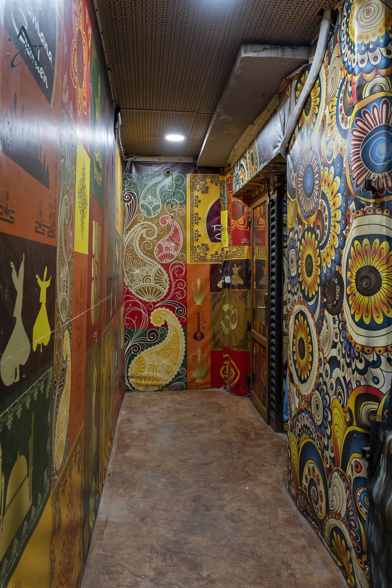 A corridor with walls adorned with colorful, intricate patterns and designs.