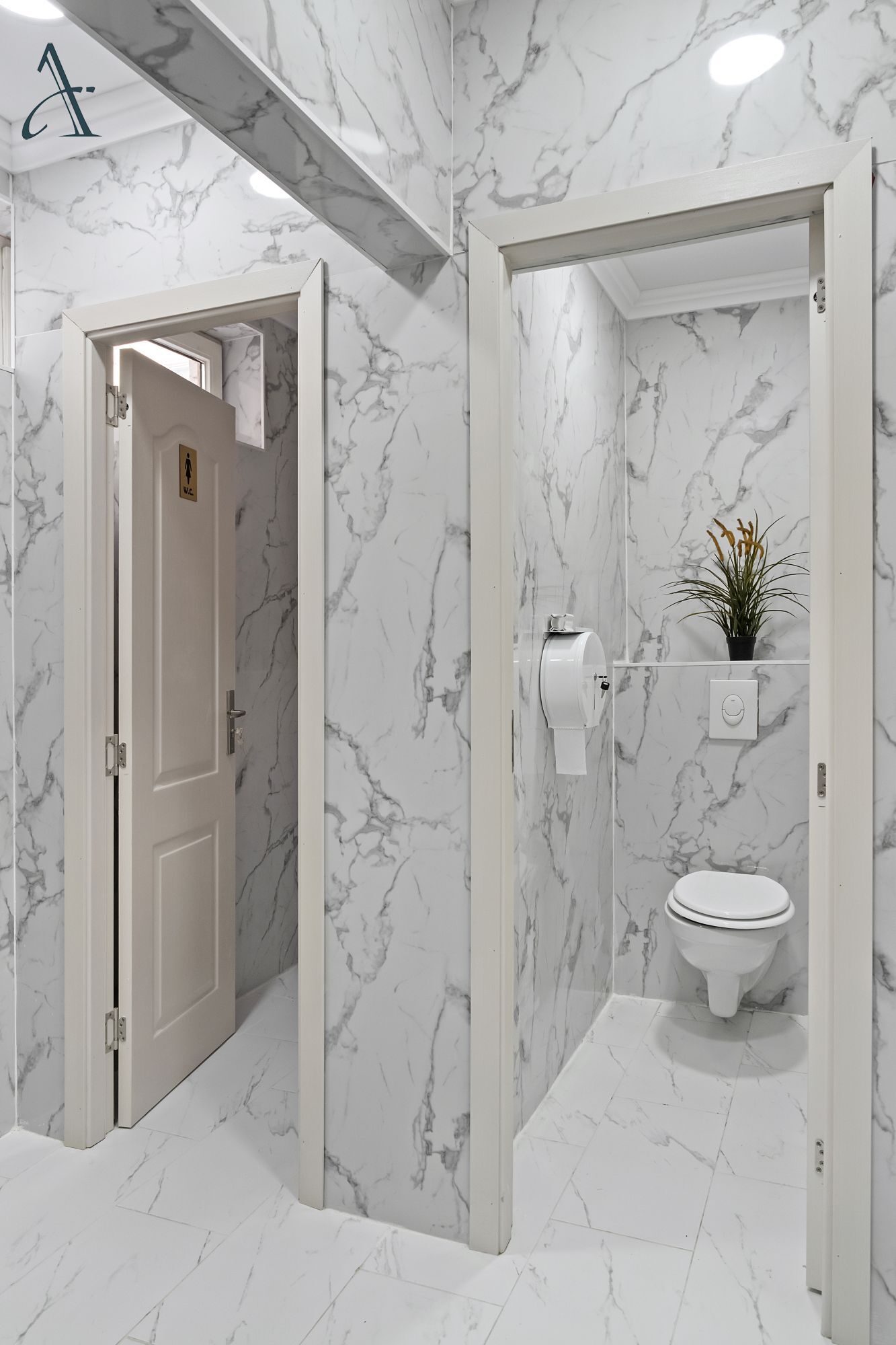 Een badkamer met marmeren wanden en een toilet.