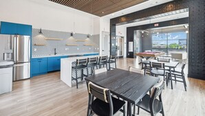 A modern kitchen with blue cabinets, a stainless steel refrigerator, and a patterned backsplash. - Stylish Music Row studio unit near Broadway (Nashville)