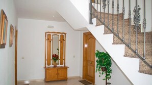 A staircase with a metal railing, a wooden door, and a potted plant. - Carmina Apartments (Carboneras)