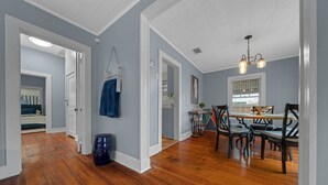 Une pièce spacieuse dotée d’un plancher en bois, d’un coin repas avec une table et des chaises, et d’un plafond pourvu d’un éclairage encastré.