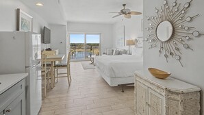A bedroom with a bed, a ceiling fan, a large mirror, and a view of the outdoors. - 6th Floor Studio Condo in Luau at Sandestin Golf & Beach Resort! (Miramar Beach)