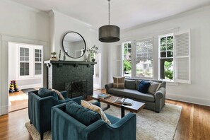 Ein Wohnzimmer mit Kamin, zwei Sofas, einem Couchtisch und einem großen Spiegel.