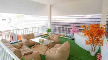 Relax in style with a comfortable seating area, complete with a table and potted plants.