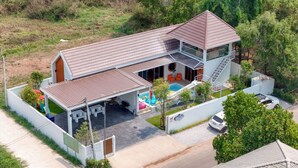 A two-story house with a swimming pool, a covered patio, and a car parked in the driveway. - Ongsa Poolvilla Udonthani (Udon Thani)