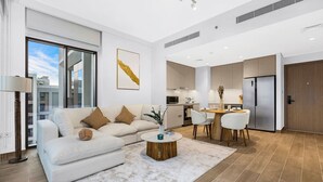 Een moderne woonkamer met een bank, salontafel en een eethoek.