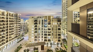 Een hoog appartementencomplex met meerdere balkons, een centrale binnenplaats en een modern architectonisch ontwerp.