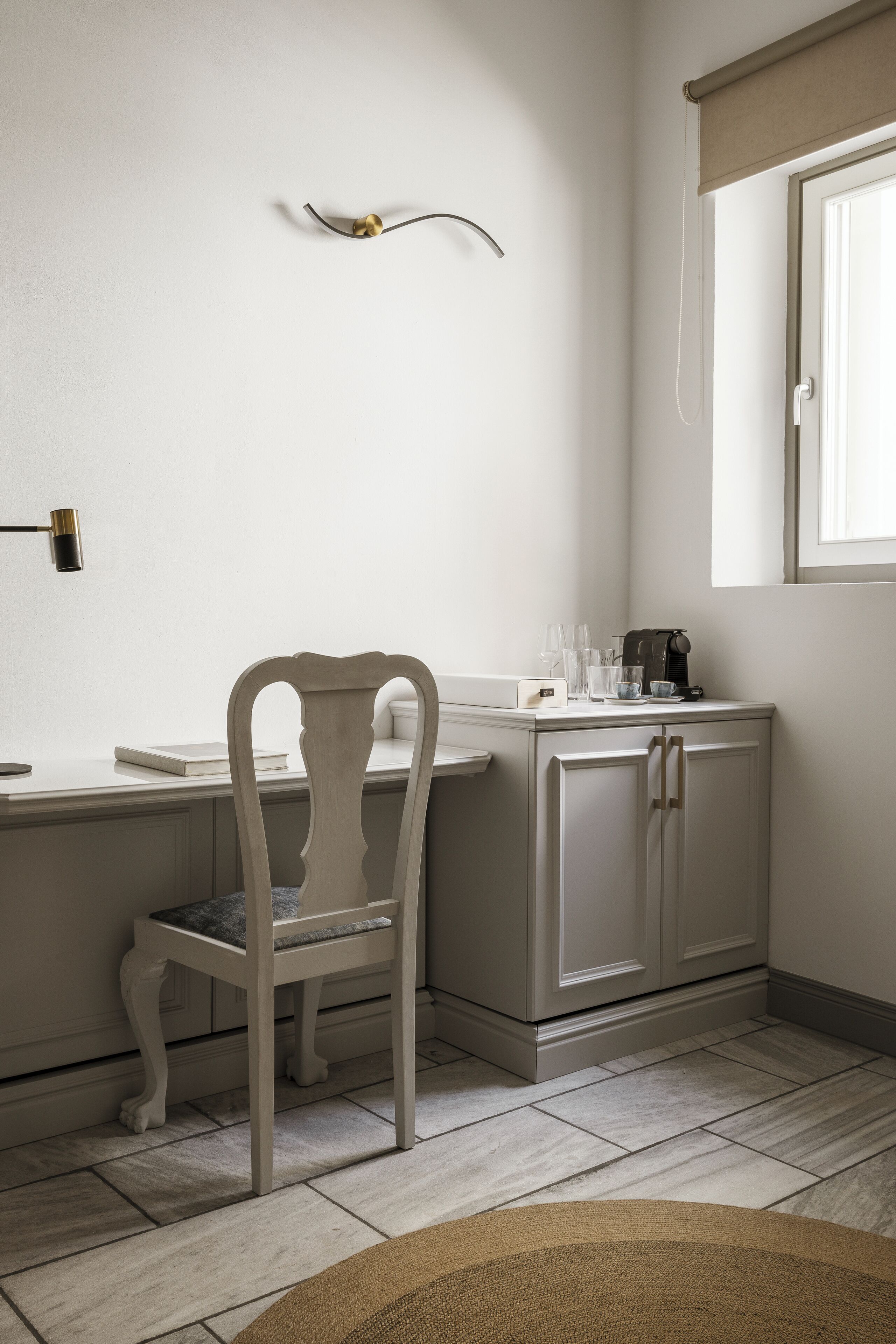 A kitchen with a white countertop, a chair, and a cabinet.