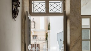 An open doorway leading to an outdoor dining area with chairs and a bicycle. - Alma Syros (Syros)