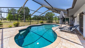 Ein überdachter Außenpool mit Terrasse, Liegestühlen und einer Pergola.