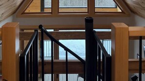 A wooden interior with a sloped ceiling and a central skylight.