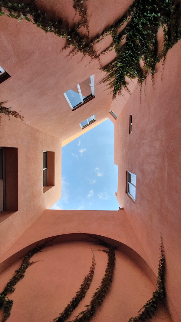 Un edificio con un interior curvo, múltiples ventanales y un cielo despejado visible a través de ellos.