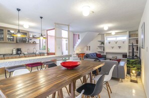 Una cocina moderna con una mesa de comedor de madera, un tazón rojo y una silla negra.