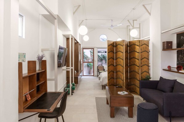 A modern interior with a desk, chair, sofa, and a partition with a zigzag pattern.