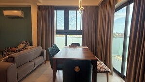Un salon moderne avec une table à manger, un canapé et de grandes fenêtres.
