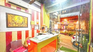 A hotel reception area with a counter, chairs, and a Buddha statue. - Hotel The Premium Villa Rishikesh (Uttarakhand)