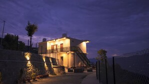 A two-story building with a balcony and a staircase leading to the upper floor.