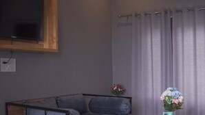 A modern living room with a grey sofa, a wooden coffee table, and a ceiling fan.